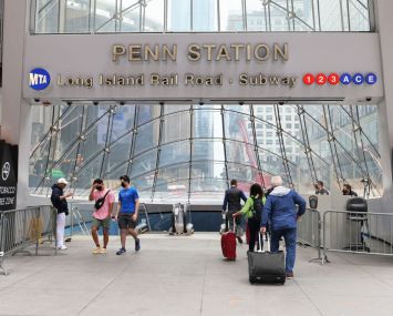 People prepare to enter Penn Station in Midtown Manhattan on May 28, 2021 in New York City.