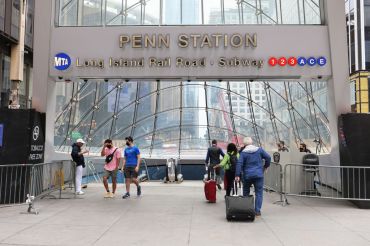 People prepare to enter Penn Station in Midtown Manhattan on May 28, 2021 in New York City.
