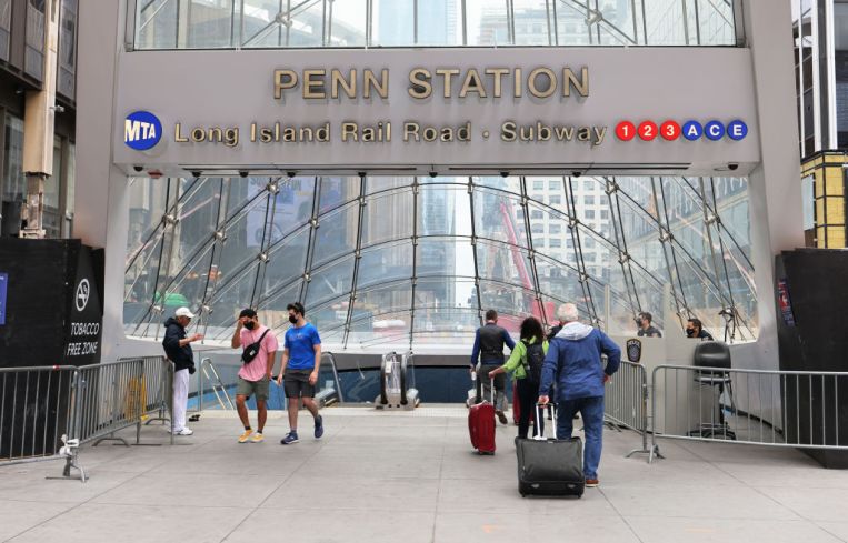 People prepare to enter Penn Station in Midtown Manhattan on May 28, 2021 in New York City.