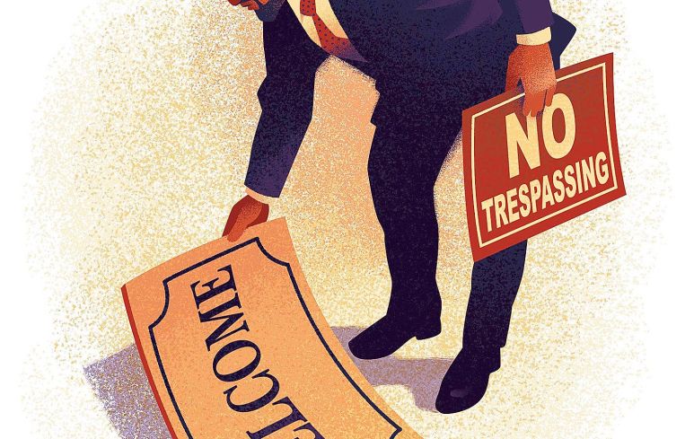 A man holds out a welcome mat.