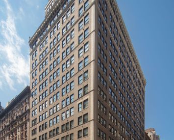 The large grey building from a viewpoint of the ground at 498 Seventh Avenue.