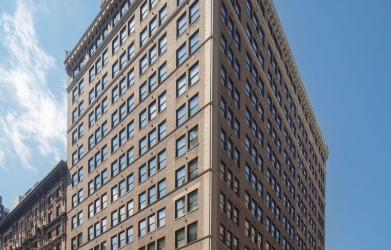 The large grey building from a viewpoint of the ground at 498 Seventh Avenue.