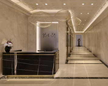 The lobby of 16 East 34th Street is adorned with black and white marble and a long hallway on the right side..