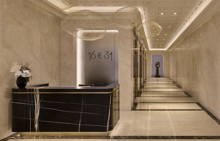 The lobby of 16 East 34th Street is adorned with black and white marble and a long hallway on the right side..