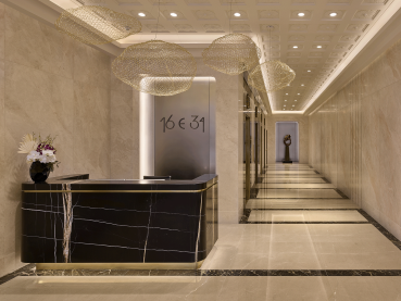 The lobby of 16 East 34th Street is adorned with black and white marble and a long hallway on the right side..