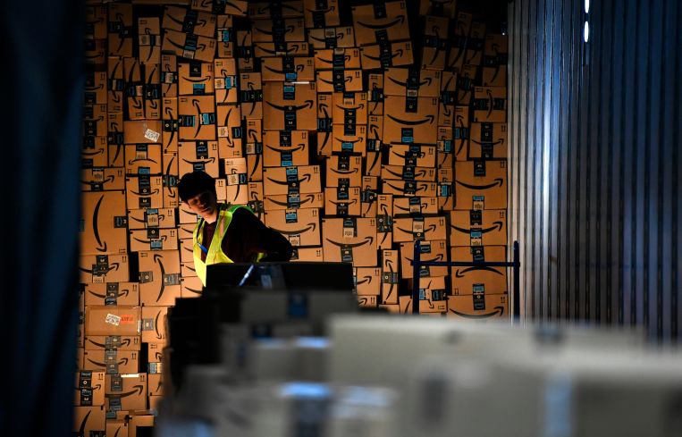 Jared Villarreal loads boxes into a trailer of a truck to be shipped out at Amazon's fulfillment center.