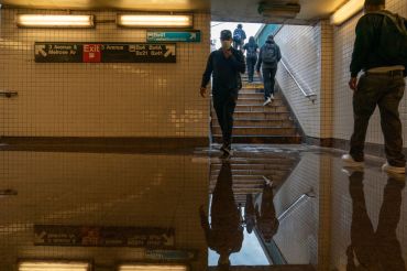 Commuters walk into a flooded subway station in the Bronx in September 2021, when Hurricane Ida dumped three inches of rain on New York City in an hour.