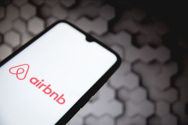 A photo illustration an Airbnb logo seen displayed on a smartphone screen.