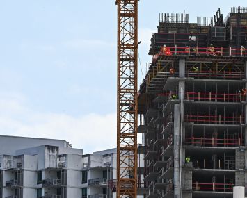 Construction workers build a residential tower in Miami, Florida