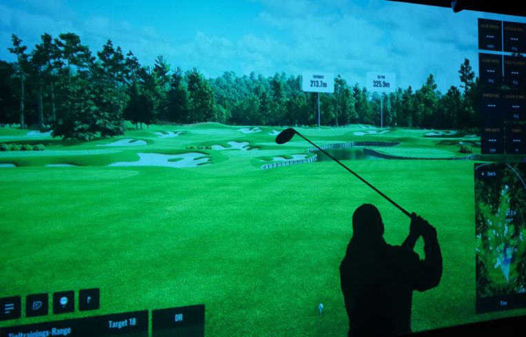 A person at an indoor golf range