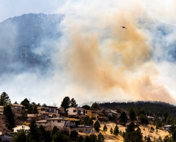 BOULDER, CO - MARCH 26: An air tanker flies above the NCAR Fire on March 26, 2022 in Boulder, Colorado. The wildfire, which has forced almost 20,000 people to evacuate their homes, started just a few miles away from where the Marshall Fire destroyed more than 1,000 homes in December, 2021.