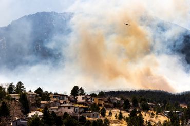 BOULDER, CO - MARCH 26: An air tanker flies above the NCAR Fire on March 26, 2022 in Boulder, Colorado. The wildfire, which has forced almost 20,000 people to evacuate their homes, started just a few miles away from where the Marshall Fire destroyed more than 1,000 homes in December, 2021. 
