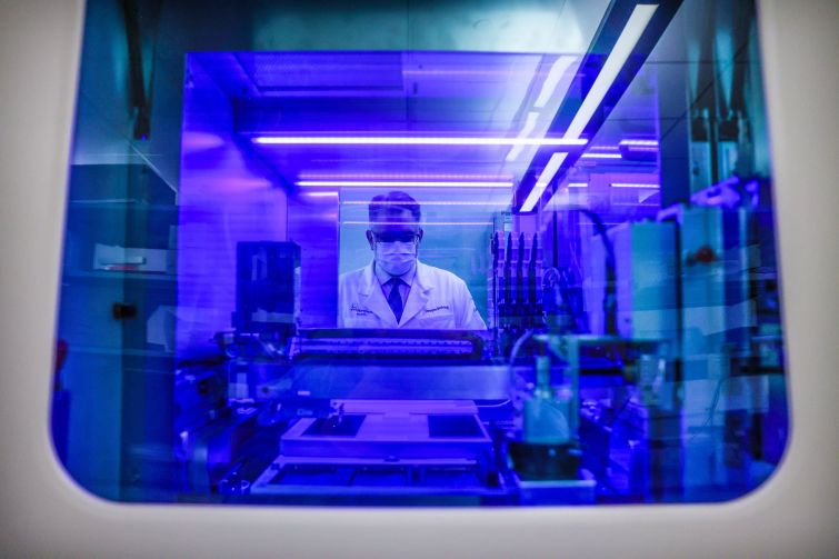 Portrait of Northwell Health Labs Executive Director Dwayne Breining in the COVID-19 testing area of Northwell's core laboratory in Lake Success, New York on June 7, 2022. He is viewed through the window of their Roche Diagnostics Cobas 8800 testing machine.
