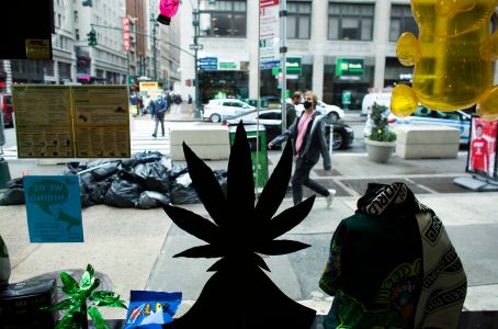 People pass in front of the Weed World store on March 31, 2021, in Midtown, New York.