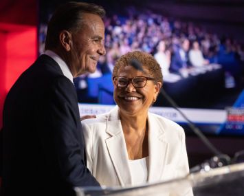 Mayoral candidates Rick Caruso and Karen Bass share a hug and a smile following a debate.