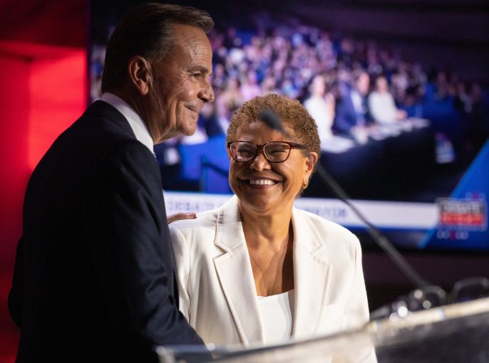 Mayoral candidates Rick Caruso and Karen Bass share a hug and a smile following a debate.