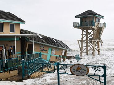 Waves crash near a damaged building and a lifeguard tower in Daytona Beach Shores in Florida.