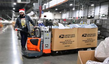 A US Postal Service employee wearing a Santa hat, sorts mail at the Los Angeles Processing and Distribution Center in preparation for another busy holiday season, November 30. The center operates 24 hours a day, 365 days a year in a warehouse the size of 22 football fields.