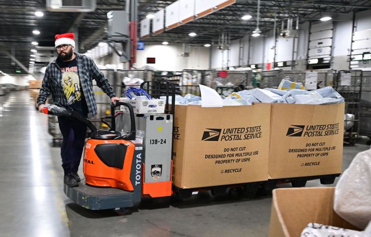 A US Postal Service employee wearing a Santa hat, sorts mail at the Los Angeles Processing and Distribution Center in preparation for another busy holiday season, November 30. The center operates 24 hours a day, 365 days a year in a warehouse the size of 22 football fields.