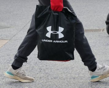 CENTRAL VALLEY, NY - NOVEMBER 17: A person carries an Under Armour bag at the Woodbury Common Premium Outlets shopping mall on November 17, 2019 in Central Valley, New York. (Photo by Gary Hershorn/Corbis via Getty Images)