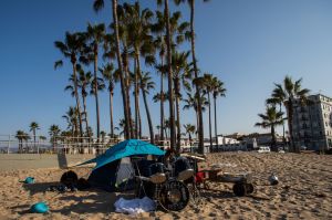 A homeless man plays drums in the early morning in Venice, California.