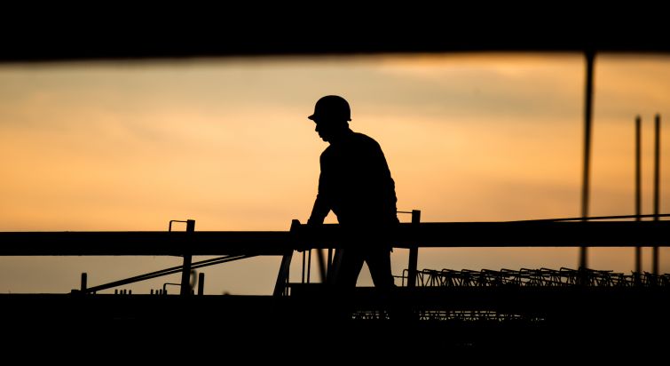 The silhouette of a construction worker.