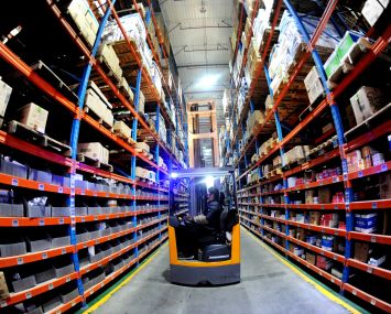 A staff member delivers goods according to an order at a warehouse of an e-commerce logistics park in December, 2022.