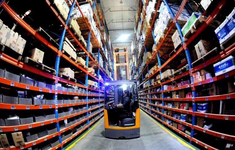 A staff member delivers goods according to an order at a warehouse of an e-commerce logistics park in December, 2022.