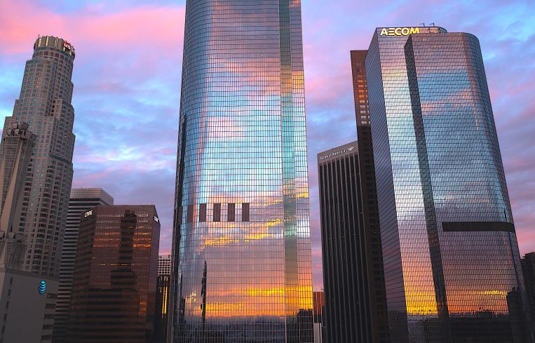The City National Bank and AECOM buildings reflect clouds at sunrise as another in a series of atmospheric river storms hit California in January 2023. The U.S. Bank, CBRE and Bank of America buildings are visible behind them.