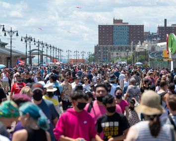 NEW YORK, NEW YORK - JULY 04: People walk along a densely populated boardwalk on the Fourth of July at Coney Island on July 4, 2021 in the Brooklyn borough of New York City. This year’s celebrations including, the annual Nathan’s hot dog eating contest, and the Macy’s 4th of July fireworks display, are happening at full capacity following smaller or mostly virtual celebrations in 2020 due to the coronavirus pandemic. (Photo by Alexi Rosenfeld/Getty Images)