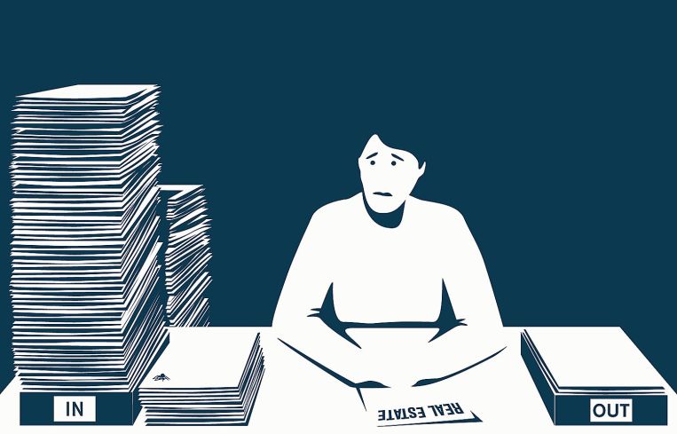 A figure looks in anguish at a massive stack of papers.
