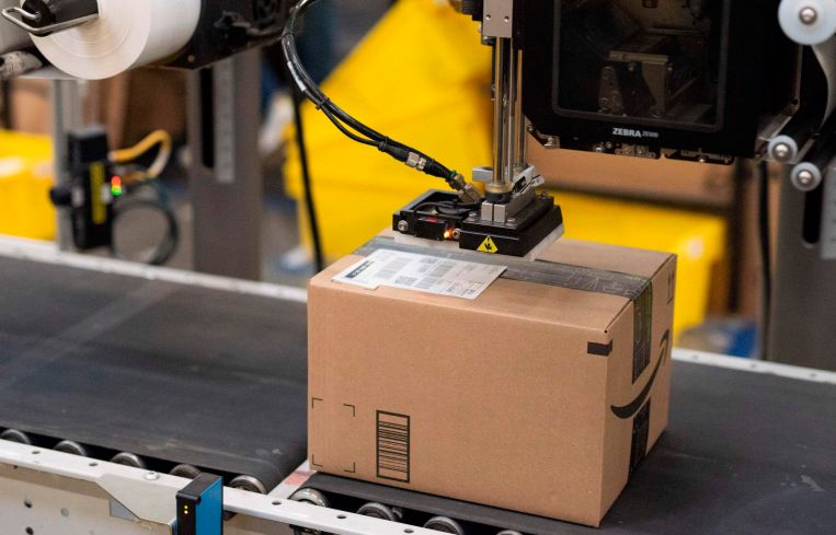 A package is labeled at a SLAM, or scan, label, apply and manifest during a tour of Amazon's Fulfillment Center.