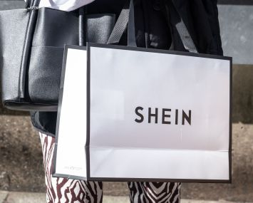 A woman holds a Shein shopping bag of Chinese online fast fashion giant Shein.