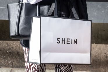 A woman holds a Shein shopping bag of Chinese online fast fashion giant Shein.