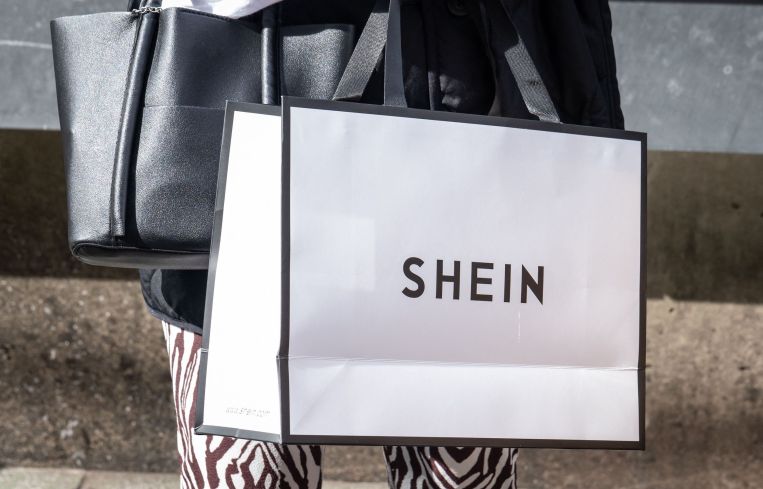 A woman holds a Shein shopping bag of Chinese online fast fashion giant Shein.