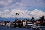 Snow blankets the San Gabriel Mountains as seen from Huntington Harbour in Huntington Beach in March, 2023.