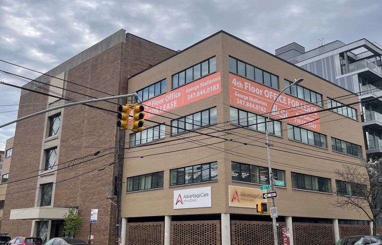 The brown, four-story building at 31-75 23rd Street, Queens.