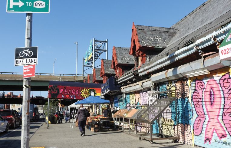 The renovation will involve removing the roll down gates and existing storefronts and recreating the old facade with large windows and glittering metal panels.
