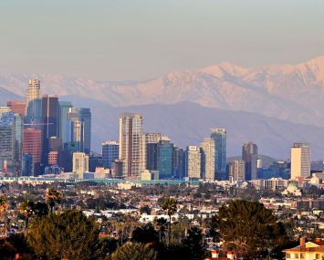 Snow-capped mountains behind the downtown skyline on March 2, 2023 in Los Angeles.