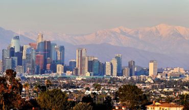 Snow-capped mountains behind the downtown skyline on March 2, 2023 in Los Angeles.