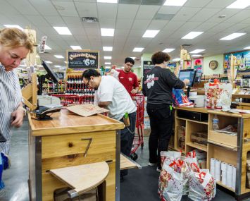 A Trader Joe's grocery store customer at check out counter with cashier.