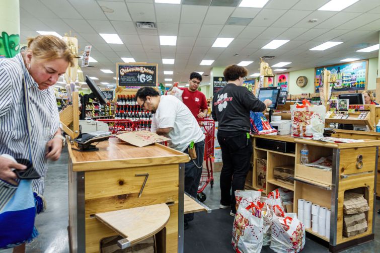 A Trader Joe's grocery store customer at check out counter with cashier.
