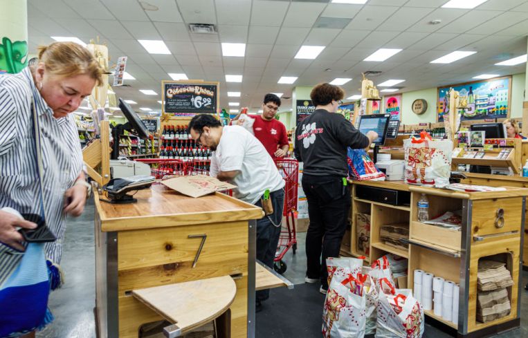 A Trader Joe's grocery store customer at check out counter with cashier.