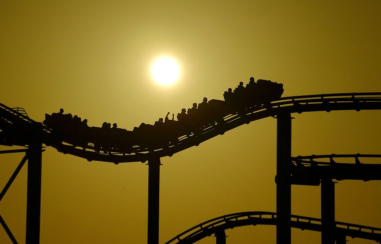 The sun sets behind a roller coaster on the Santa Monica Pier on April 15.