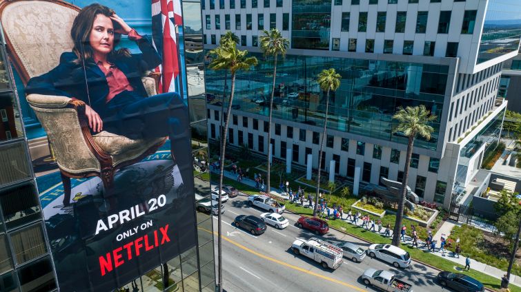 A billboard for a Netflix streaming show "The Diplomat" on a building across the street where WGA members walk a picket line around HPP's Bronson Sunset Studios where Netflix leases space for production and offices.
