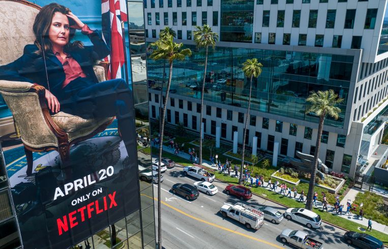 A billboard for a Netflix streaming show "The Diplomat" on a building across the street where WGA members walk a picket line around HPP's Bronson Sunset Studios where Netflix leases space for production and offices.