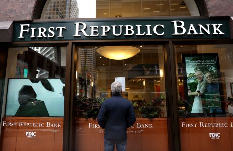 A passerby stops to read a posted announcement from the FDIC about the seizure of First Republic Bank and sale to JPMorgan Chase on May 01, 2023