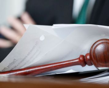 A gavels sits on a desk of papers.
