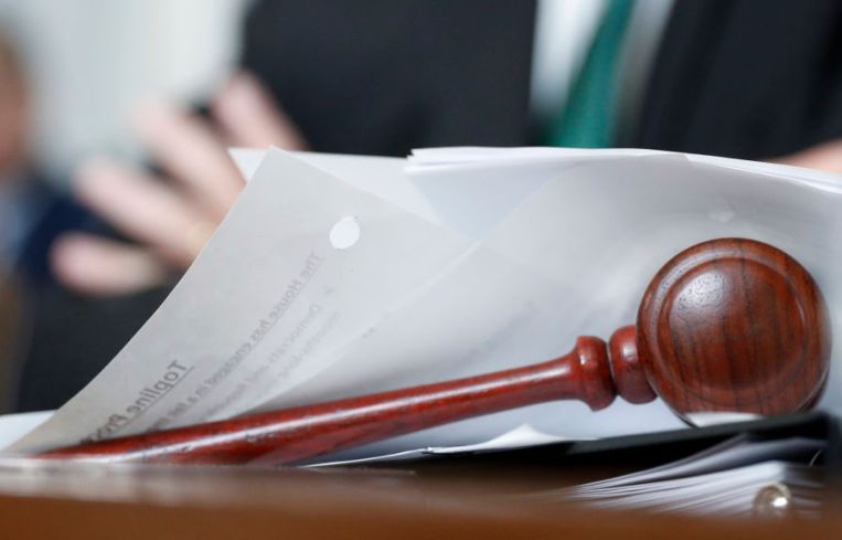 A gavels sits on a desk of papers.