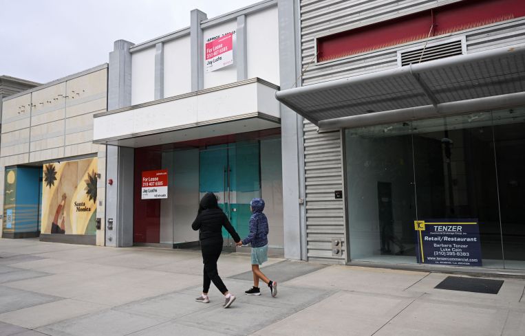 Pedestrians walk past vacant retail store fronts for lease along the Third Street Promenade in Santa Monica on March 20, 2023.
